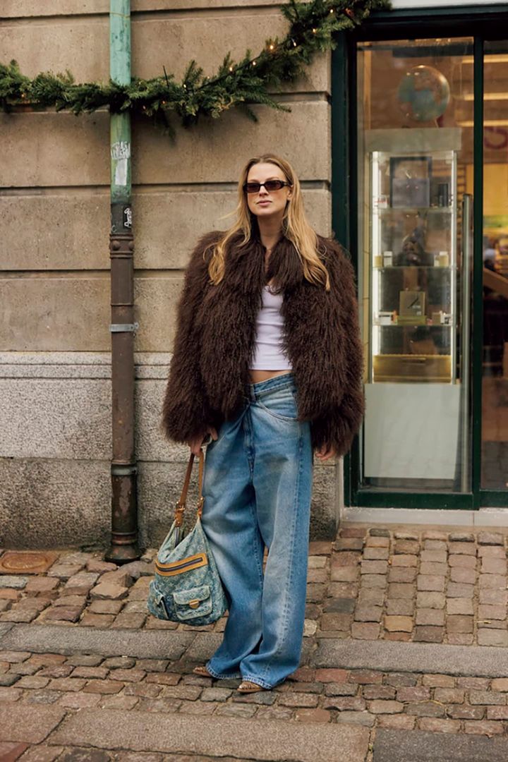 Woman wearing a brown faux fur coat with jeans