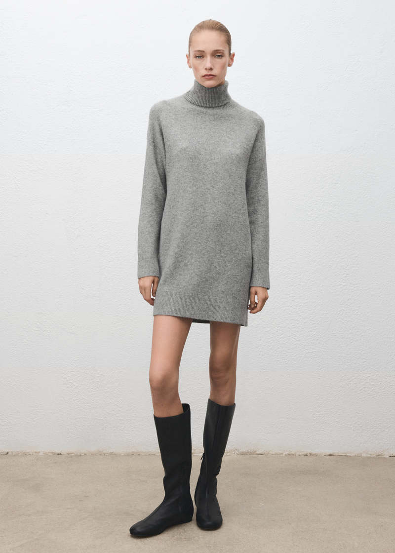 Woman wearing a turtleneck sweater dress with knee-high boots