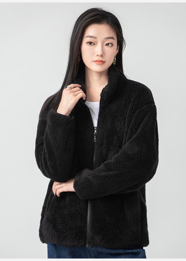 Woman in a black sherpa fleece jacket over a white tee