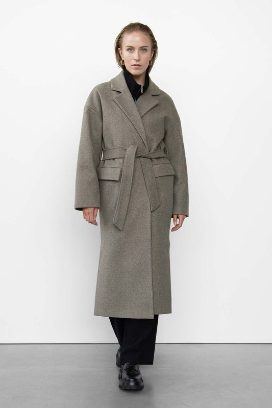 Belted gray wool coat worn over black layers with chunky black boots