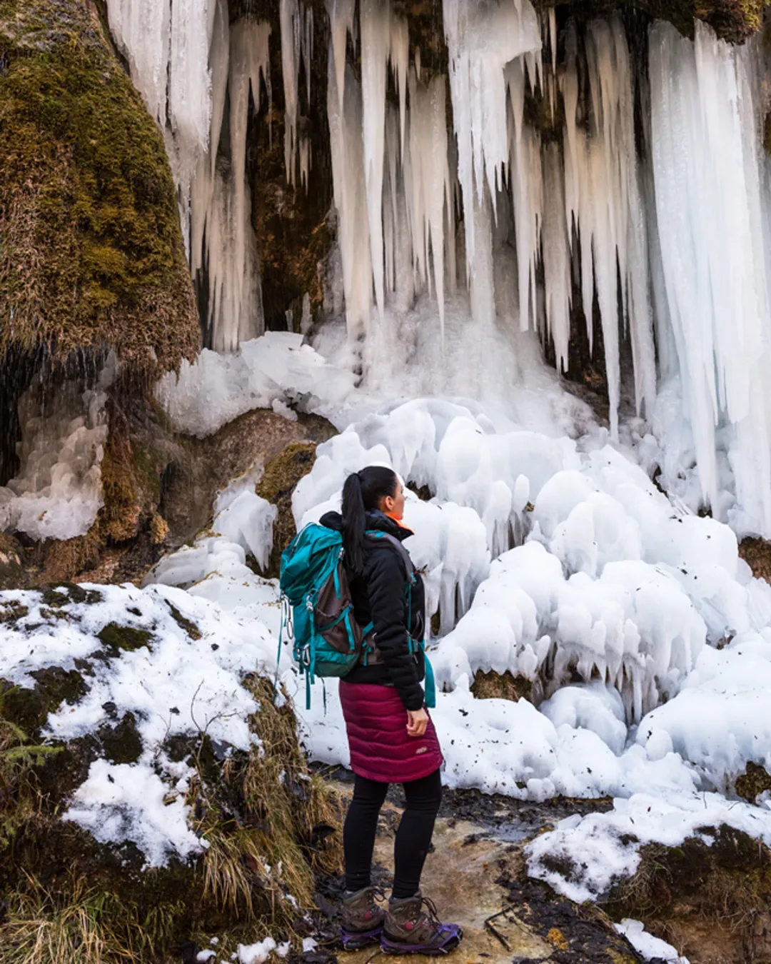 Woman in winter hiking layers on a scenic mountain viewpoint trail