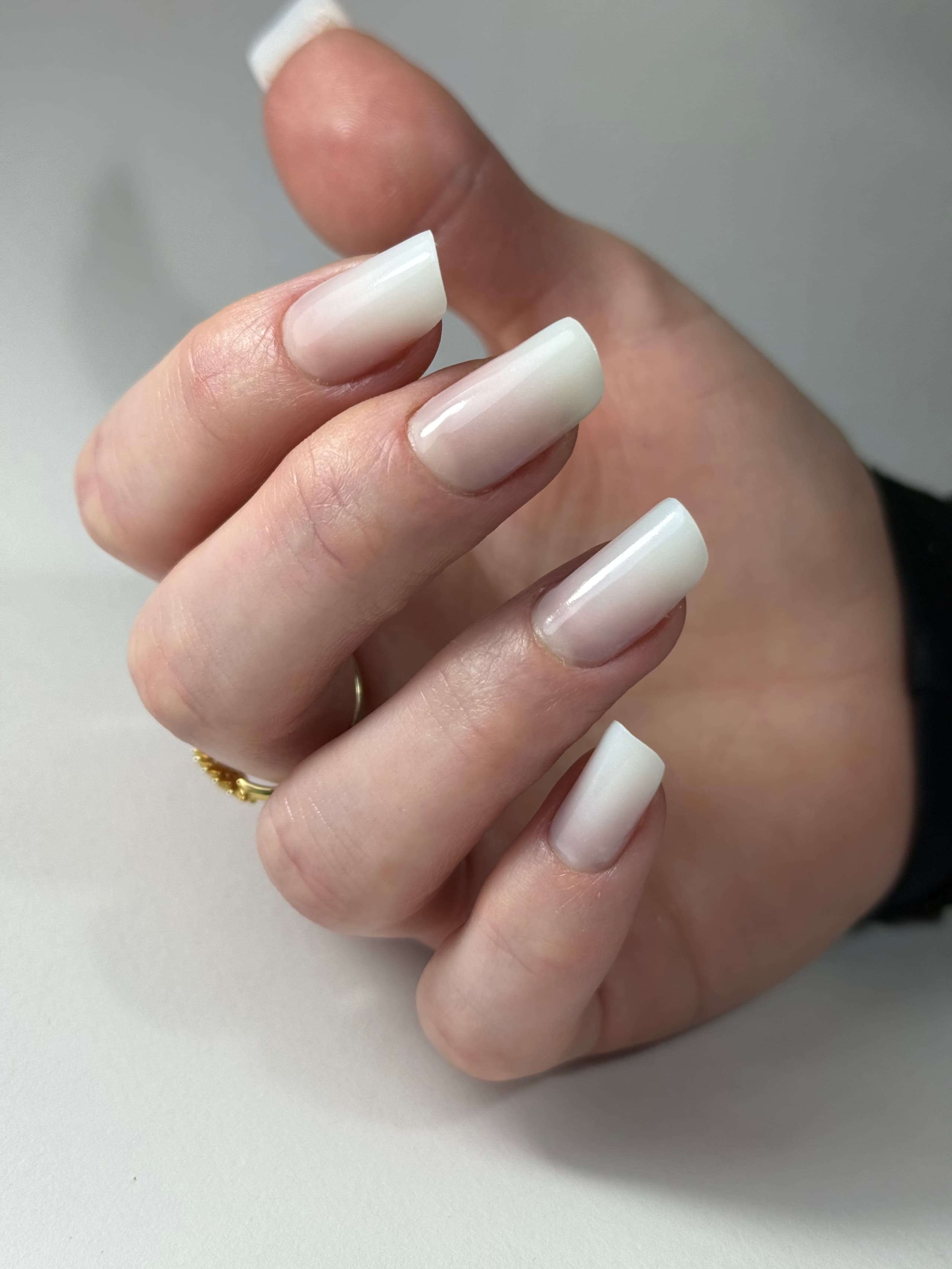 Baby boomer ombre nails fading from nude to white on long square nails