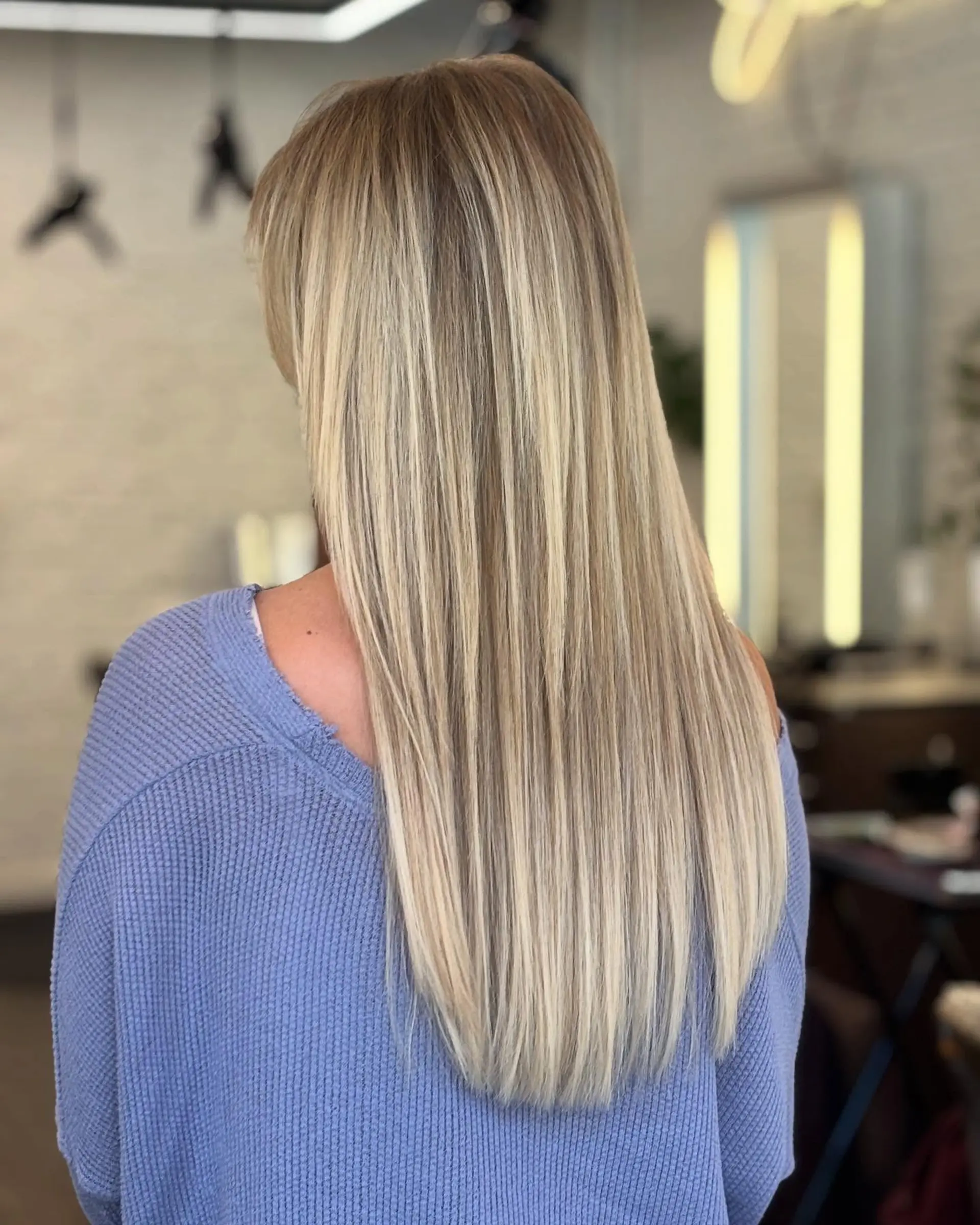 Buttery blonde balayage with a subtle shadow root on long straight hair