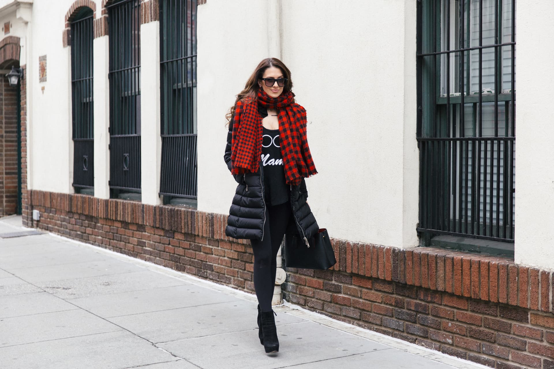 Woman in a black puffer coat styled with a red scarf
