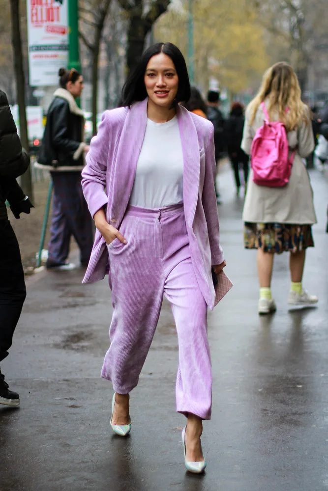 Woman in a velvet suit with wide-leg trousers in winter fashion week street style