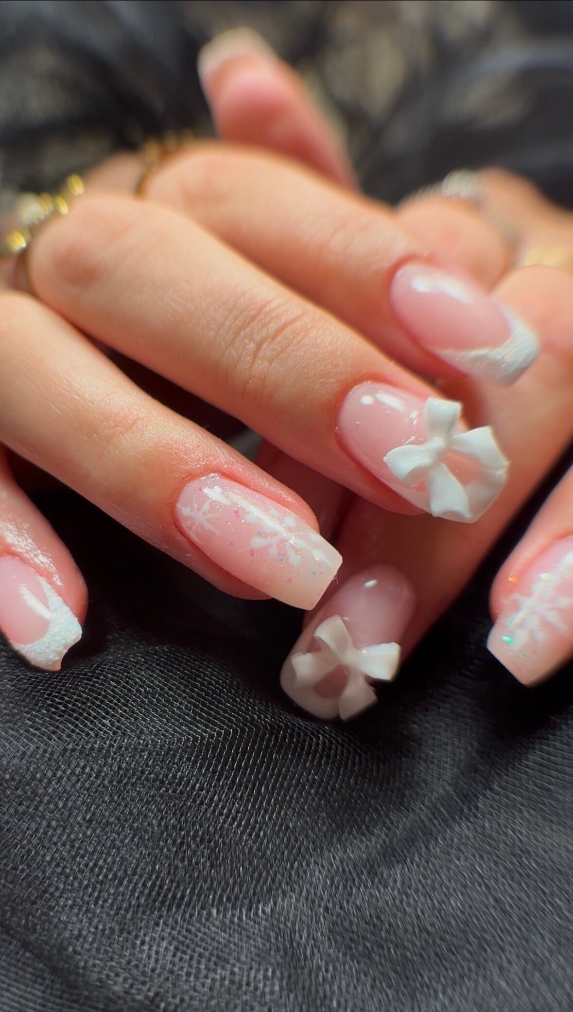 Square nails with pink French tips, white 3D bows and delicate snowflake nail art