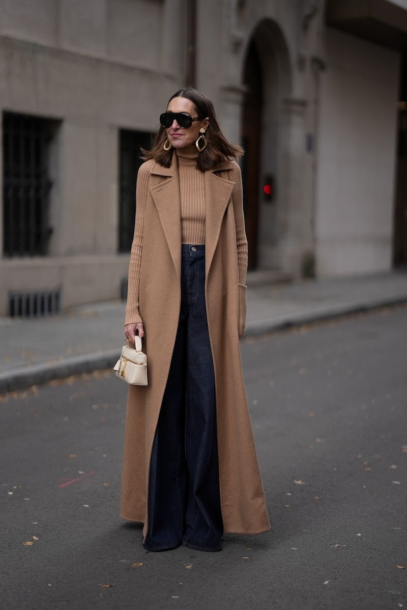 Woman wearing a camel coat with dark denim