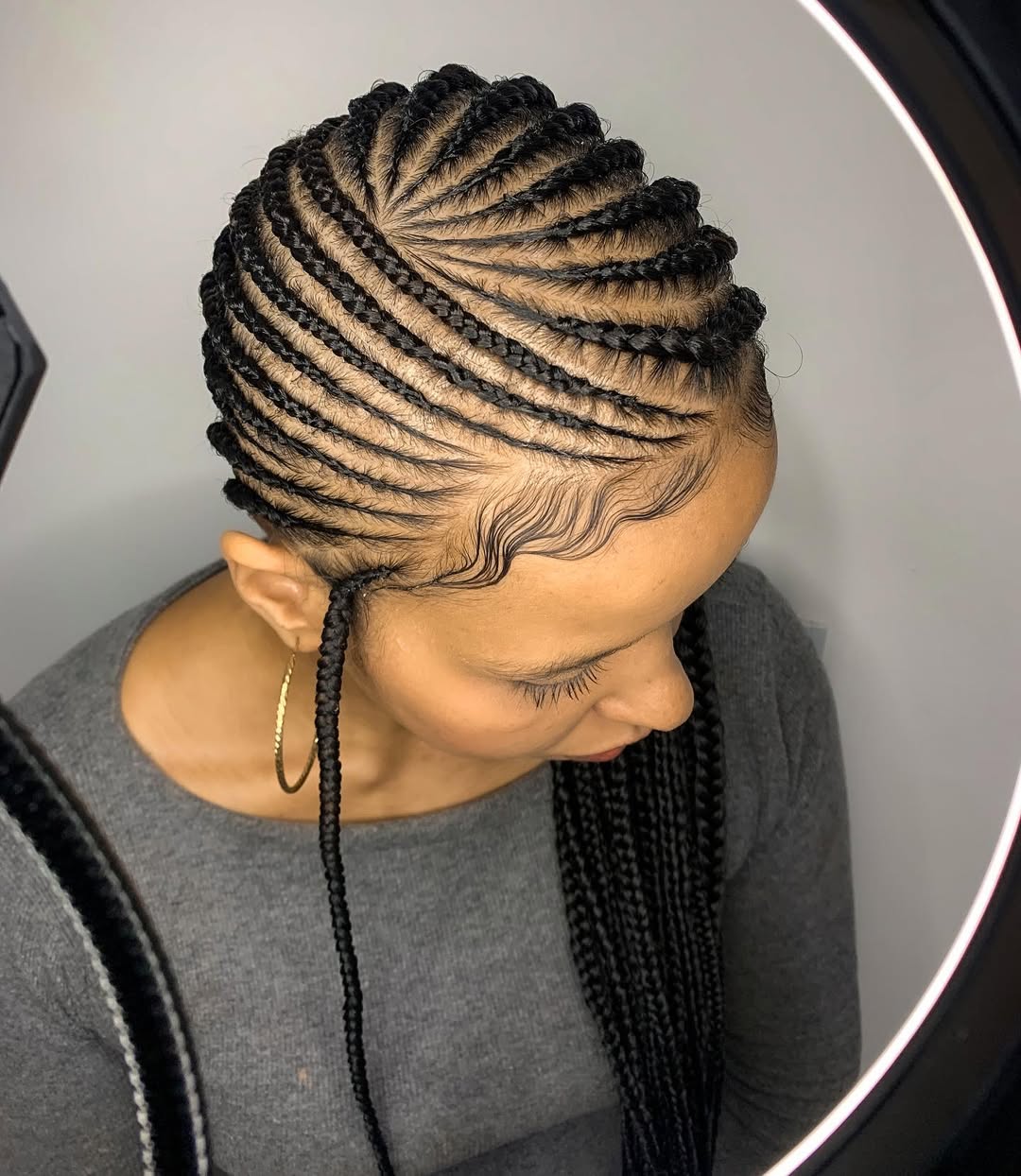 Jet-black lemonade braids with defined spiral parting swept to the side