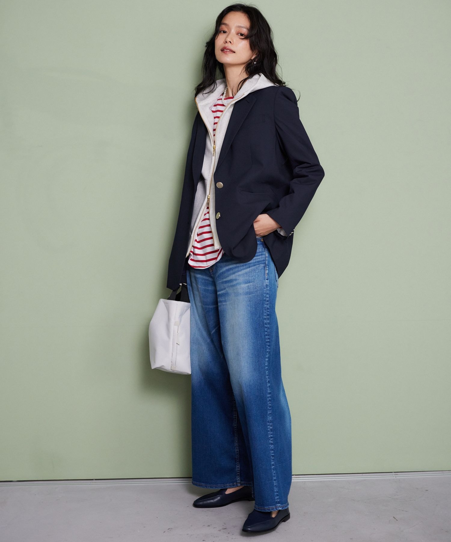 Woman in hoodie layered over striped tee with wide-leg trousers and loafers