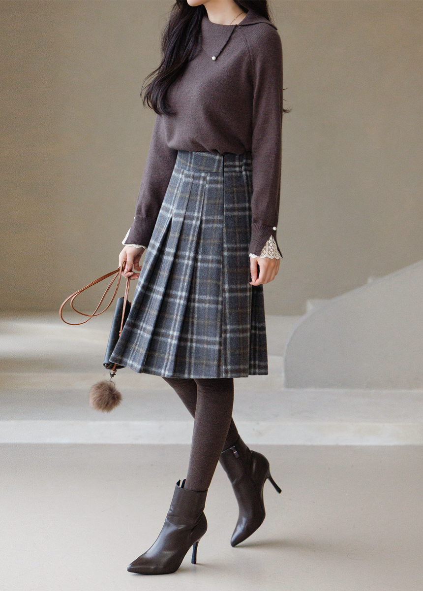Woman wearing brown tights with an autumn-toned sweater and skirt outfit