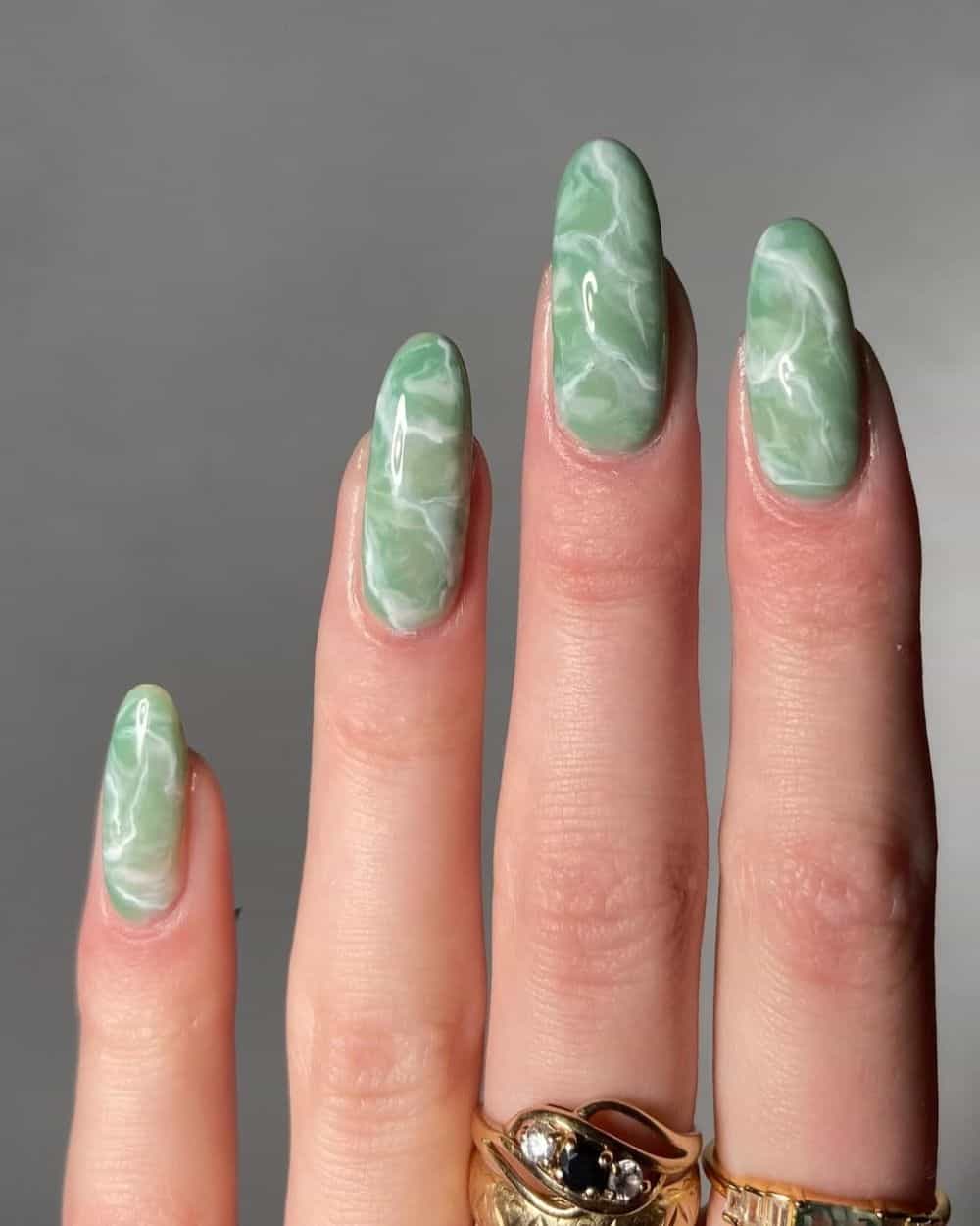 Medium almond nails in pale jade marble with white veining