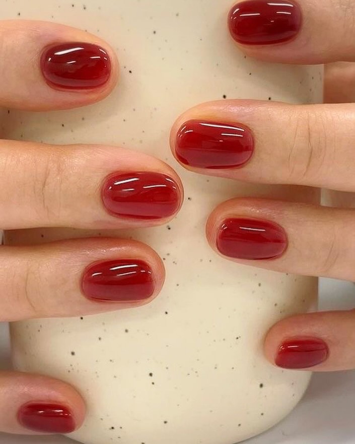 Short oval nails in translucent cranberry jelly gloss