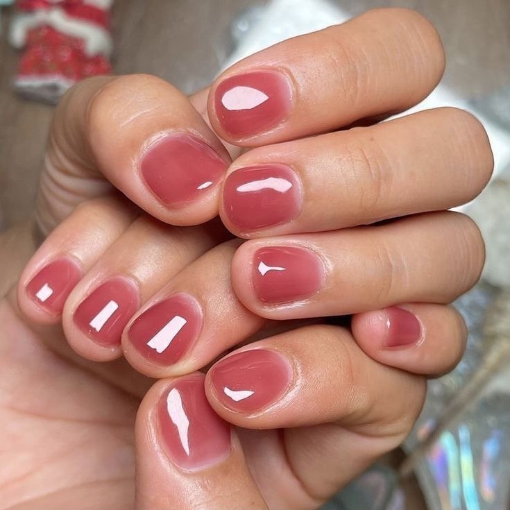 Sheer pink jelly nails with a glossy shimmer finish