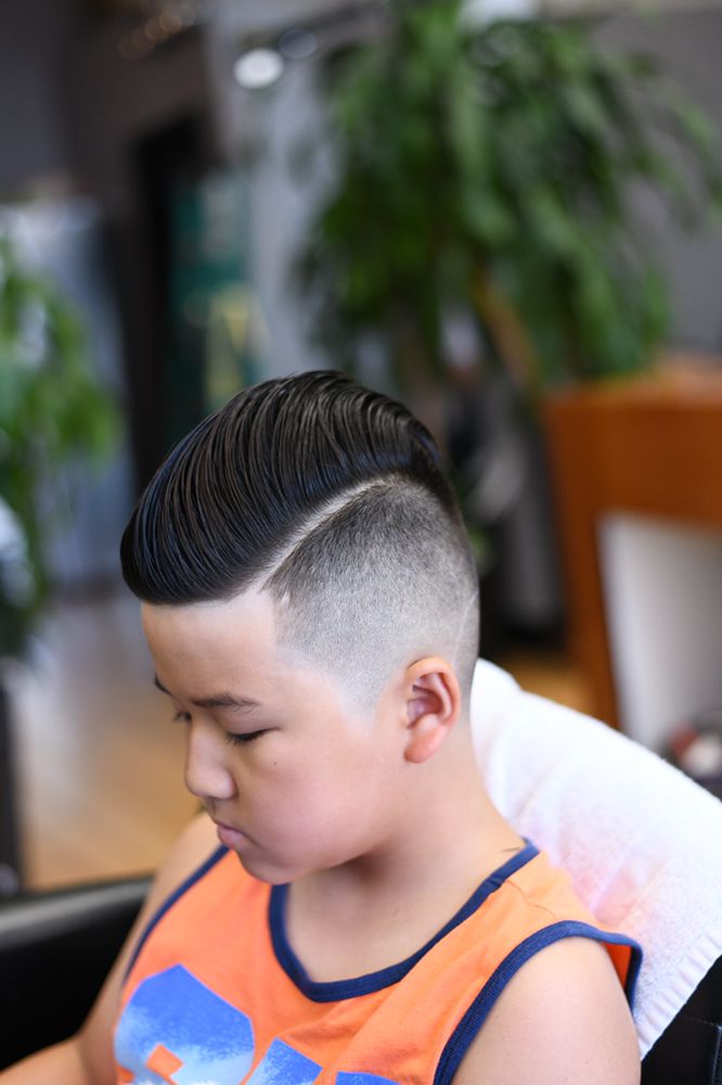 Kids pompadour haircut with tapered sides at a salon