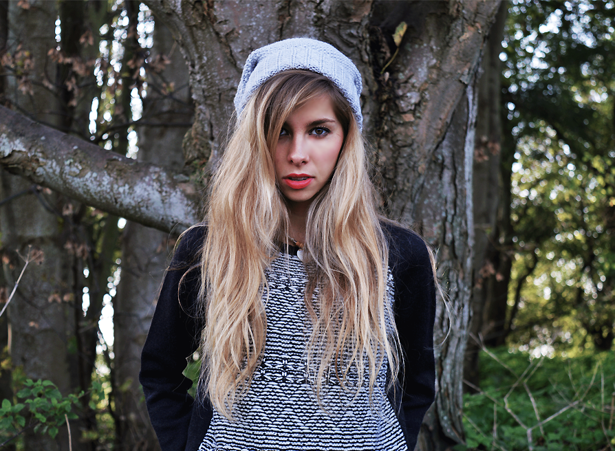 Woman in a grey beanie and patterned black and white sweater