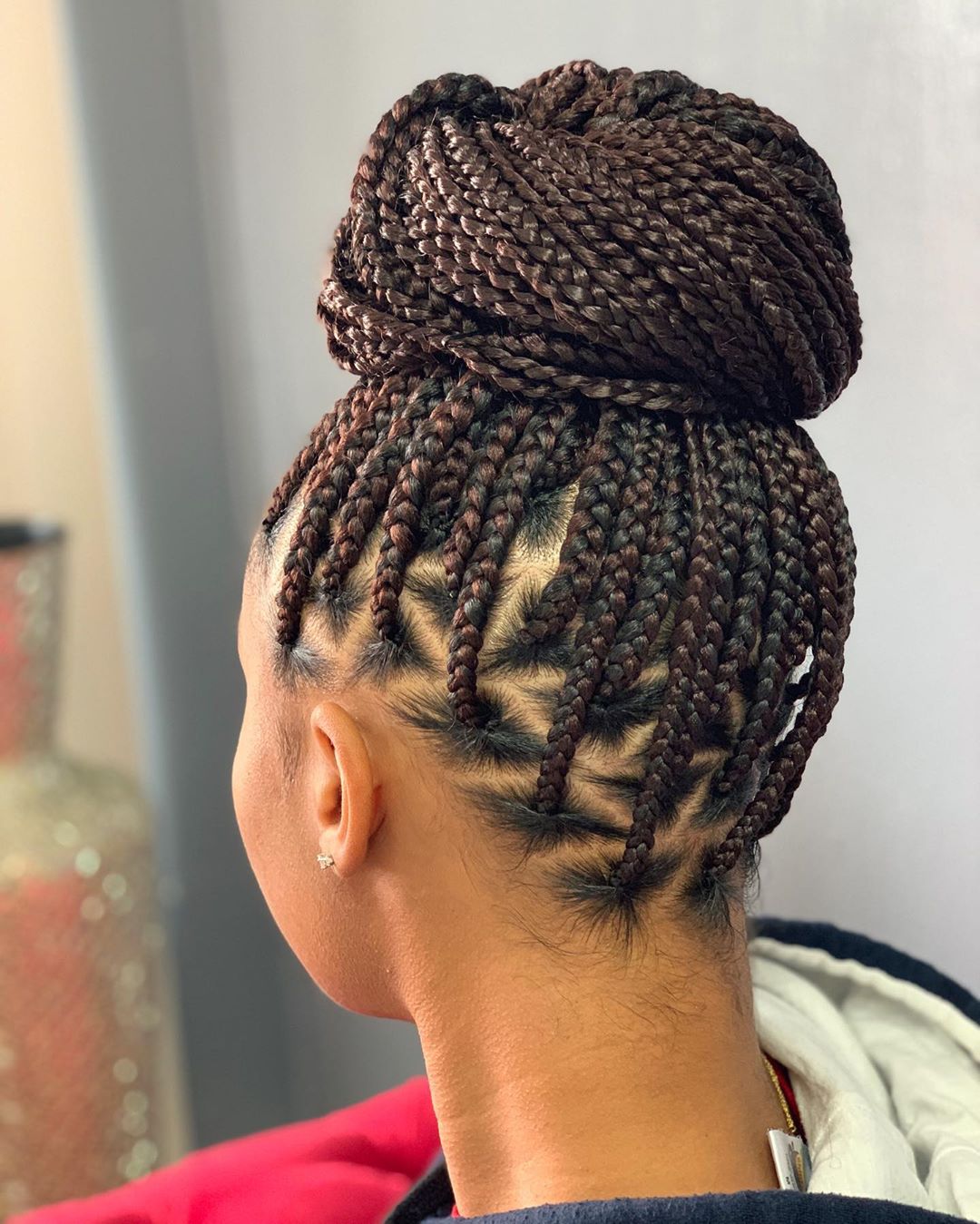 Long box braids swept up into a full top knot
