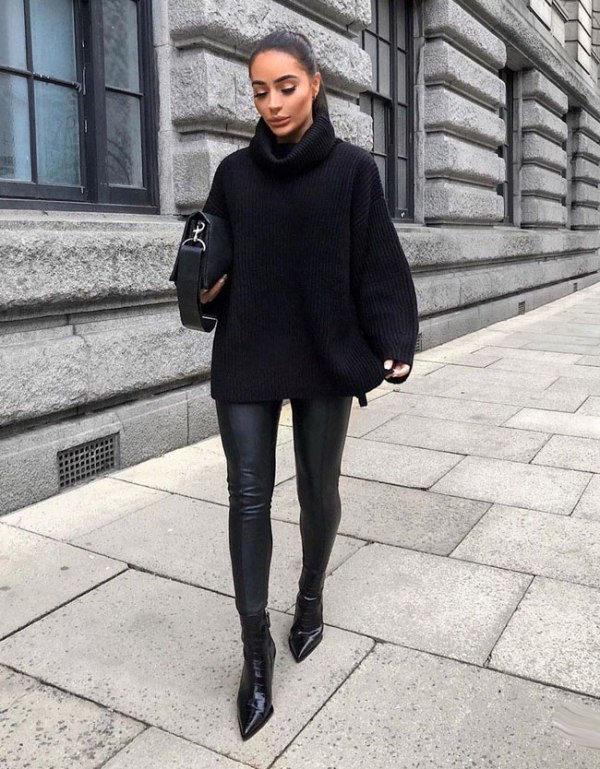 Woman wearing an oversized black turtleneck sweater with black leather leggings and pointed ankle boots