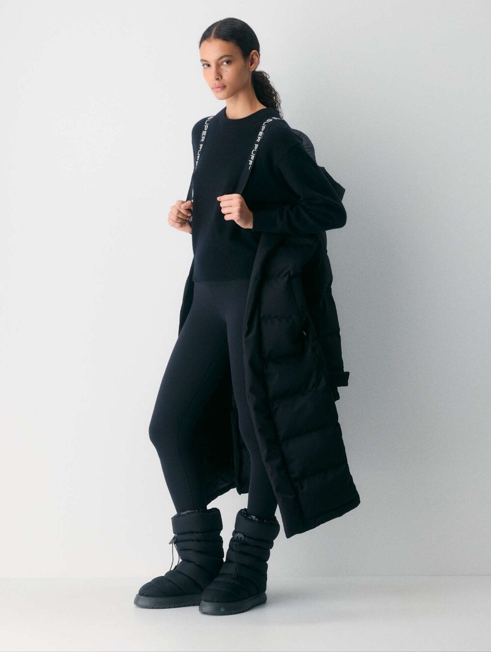 Woman wearing a long waterproof winter parka in a snow day outfit photo