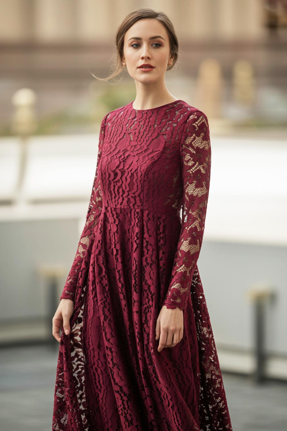Long-sleeve burgundy lace dress styled for a winter formal occasion