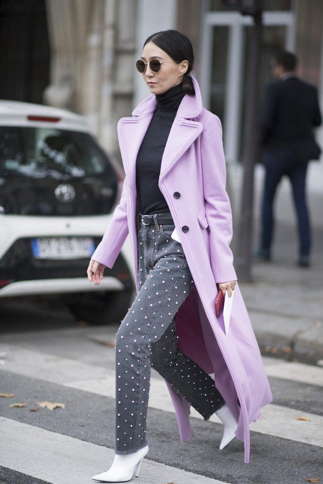 Woman wearing a lavender pastel coat with dark jeans