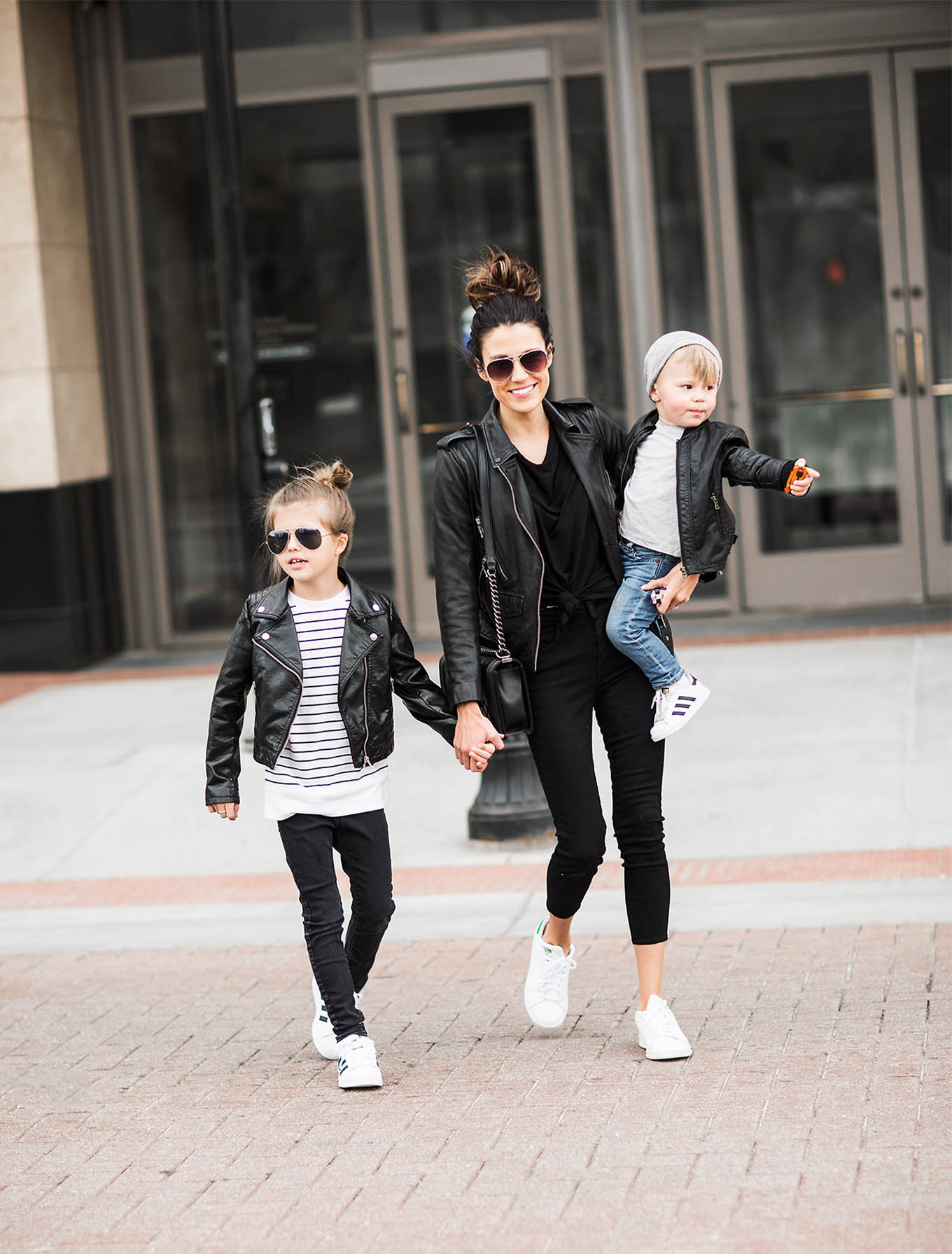 Family in matching leather jackets for a winter street-style photo