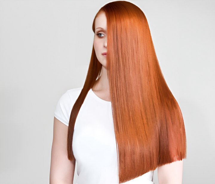 Very long one-length copper-red hair worn straight with a center part
