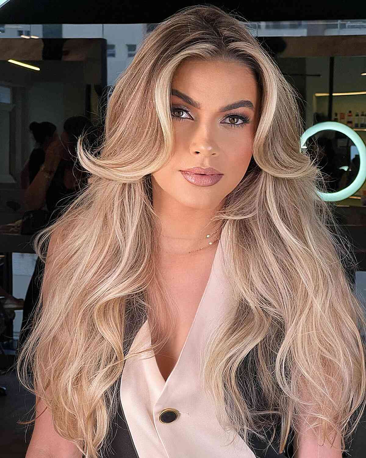Long voluminous blonde hair with face-framing layers styled in soft waves