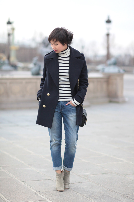 Fashion blogger in Paris wearing a navy double-breasted peacoat, Breton striped turtleneck top, cuffed skinny jeans and ankle boots
