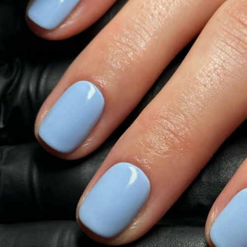 Short icy blue glossy manicure close-up