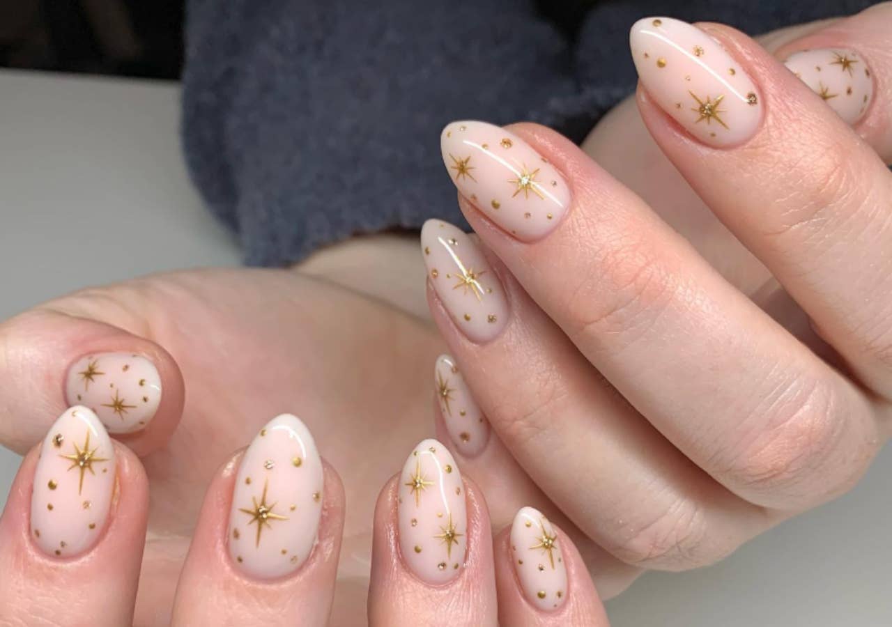 Milky white nails with tiny gold star accents