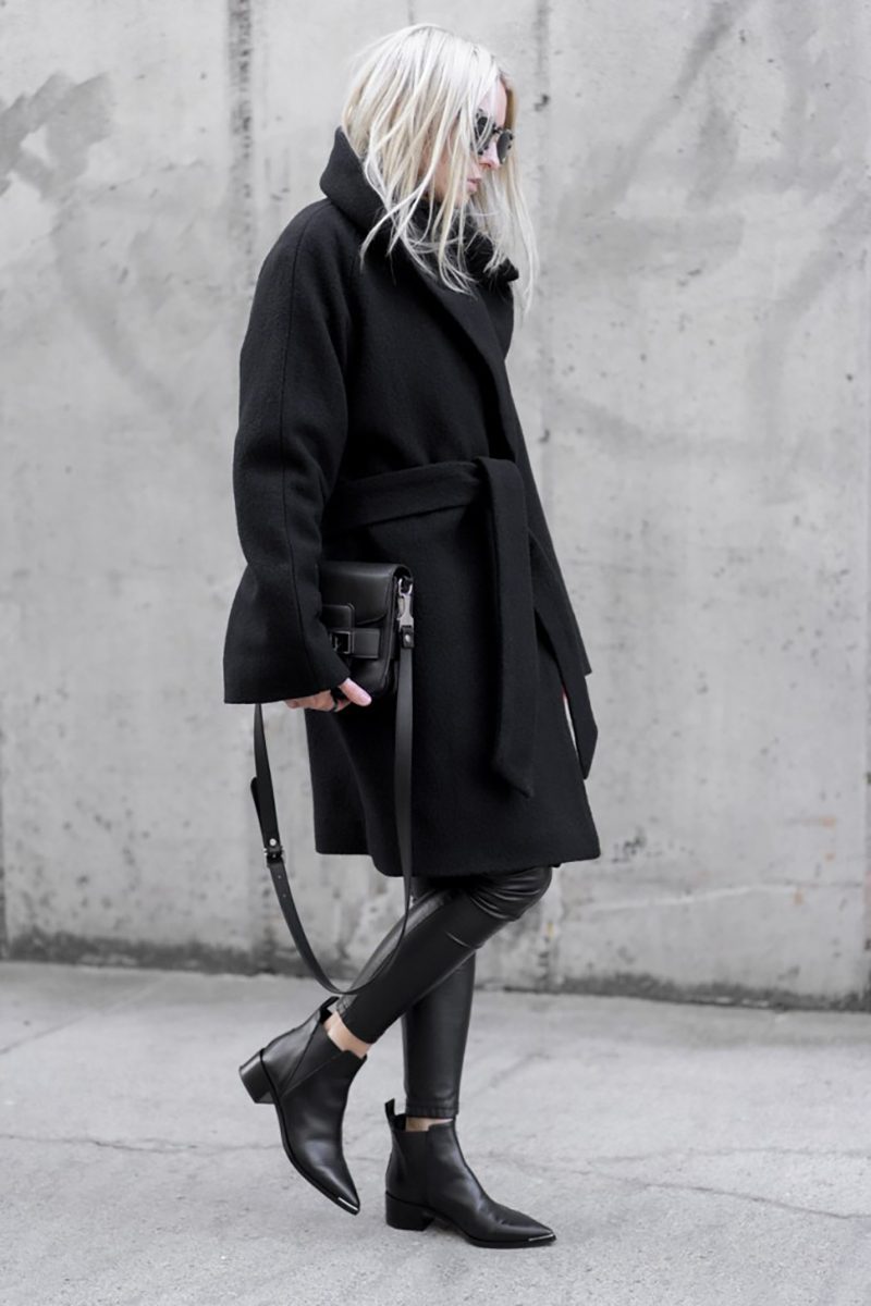 Woman wearing a black wrap coat, leather leggings and pointed black ankle boots