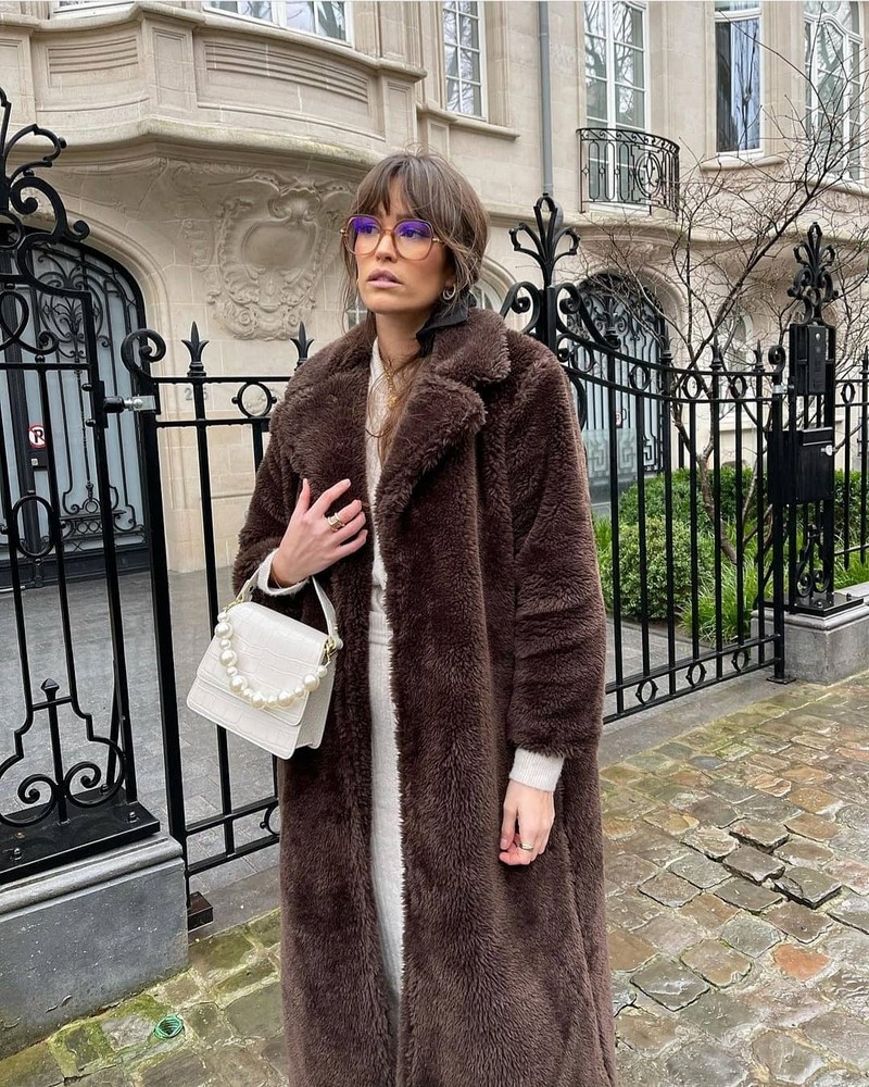 Woman in chocolate brown long faux fur coat with cream knit outfit
