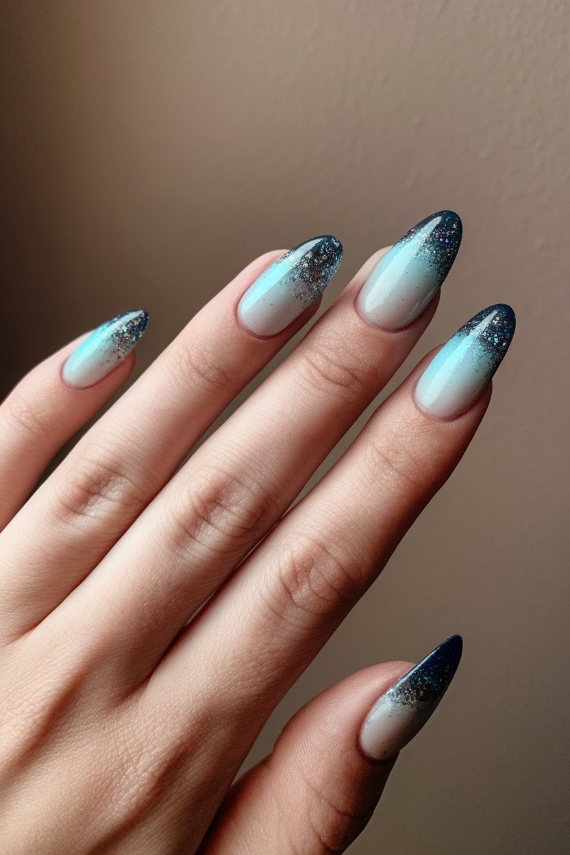 Almond nails with milky white to icy blue glitter ombre tips