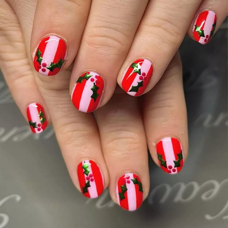 Red and pink striped nails with holly leaves and berry nail art