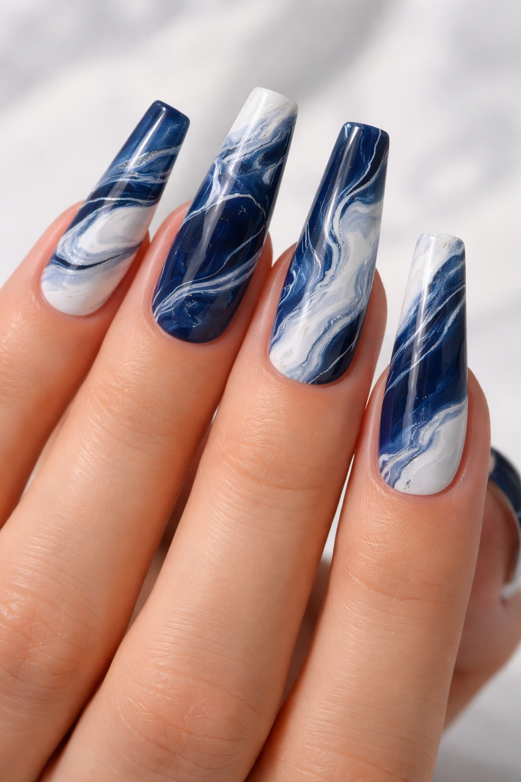 Long coffin nails with navy blue and white marble swirls