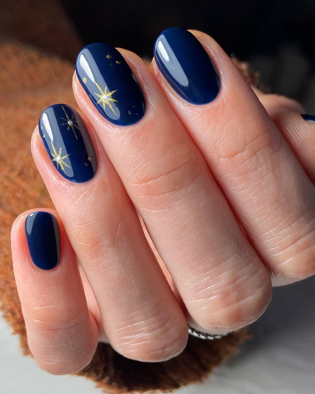 Midnight navy gel nails with gold starburst accents