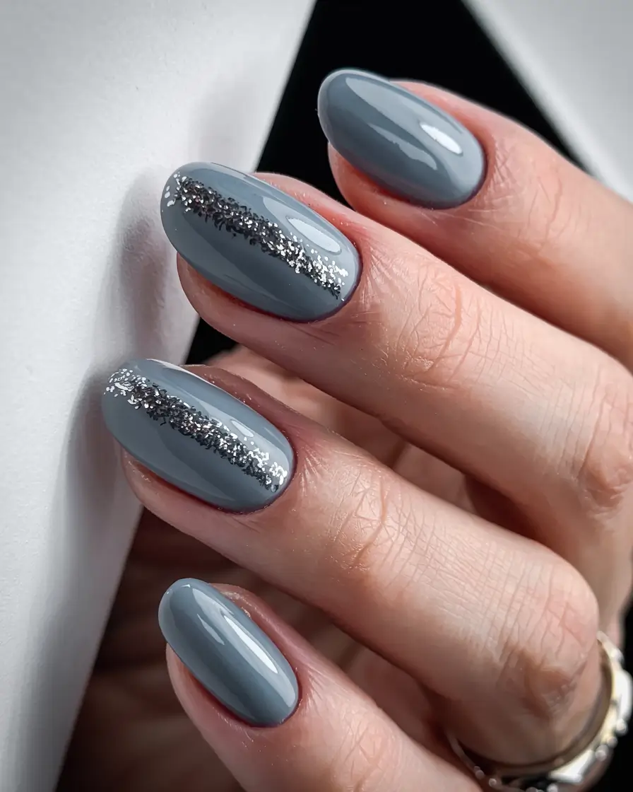 Glossy medium-gray almond nails with holographic silver sparkle stripe accents on two accent nails