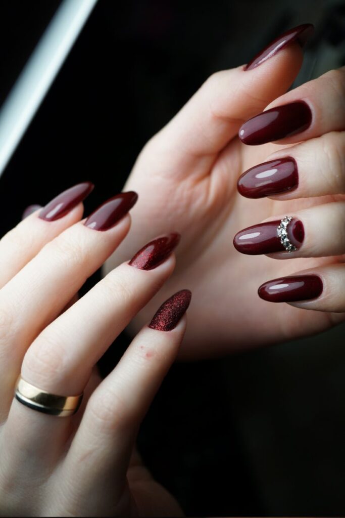 Burgundy shimmer nails with crystal band accent