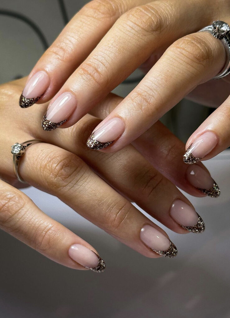Nude gel nails with dark champagne glitter French tips