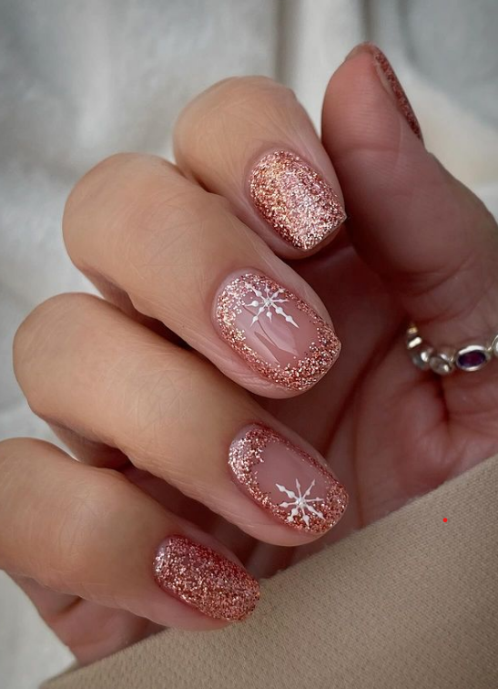 Rose gold glitter nails with white snowflake designs
