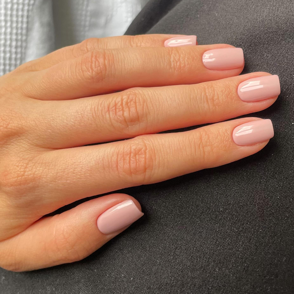 Sheer pink-nude polish on short natural nails