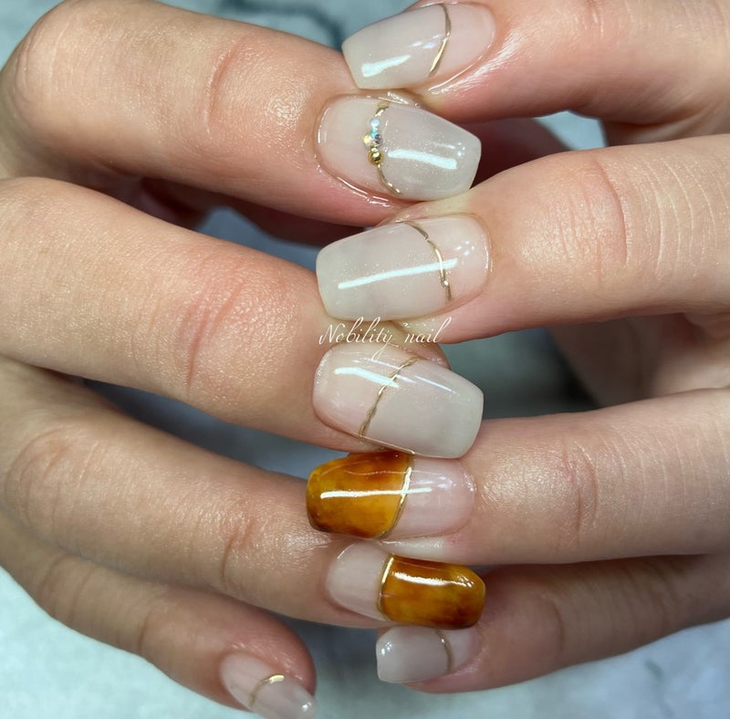 Beige Champagne: a beige-champagne gel with fine gold lines and amber accents on square nails