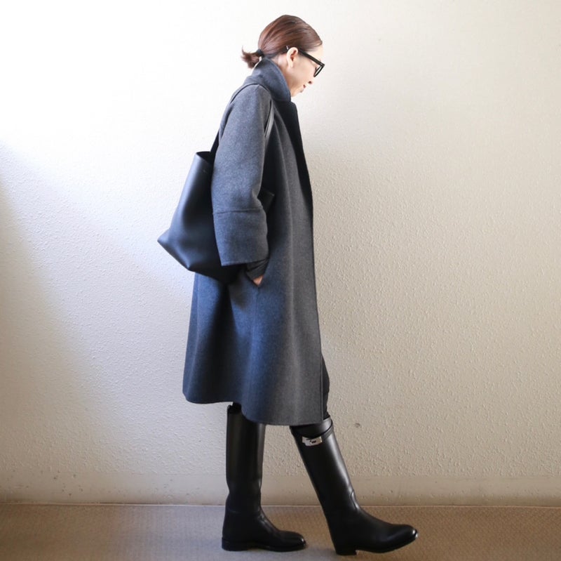 woman in long gray wool coat and black riding boots