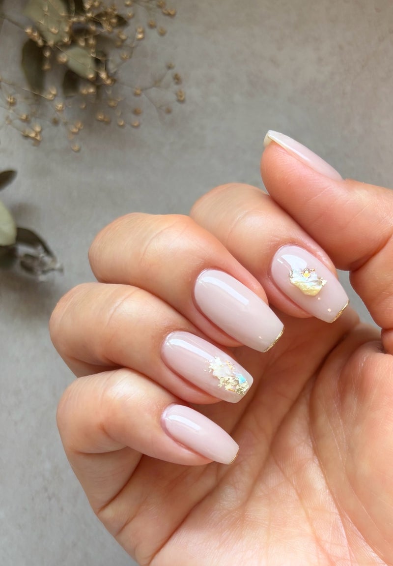 Warm Champagne Nude Cream: a warm nude-cream base with gold-foil flakes on oval nails