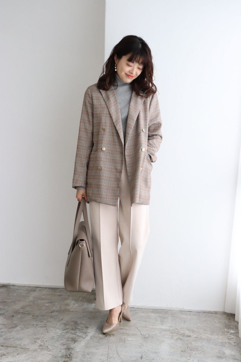 Woman in a plaid double-breasted blazer with a grey roll-neck, cream wide-leg trousers and beige heels
