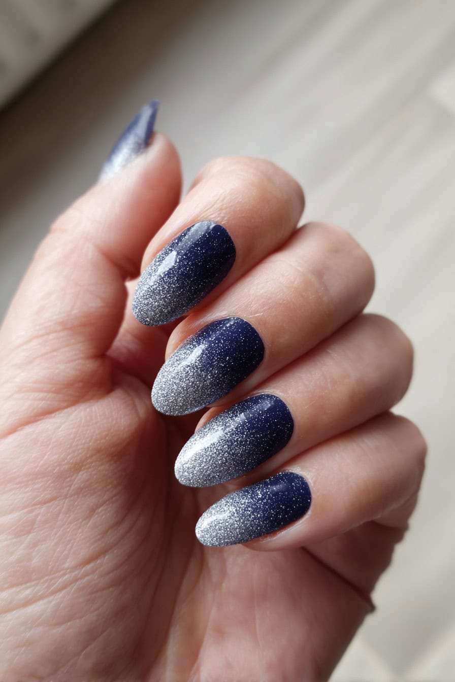 Almond nails with midnight blue to silver glitter gradient