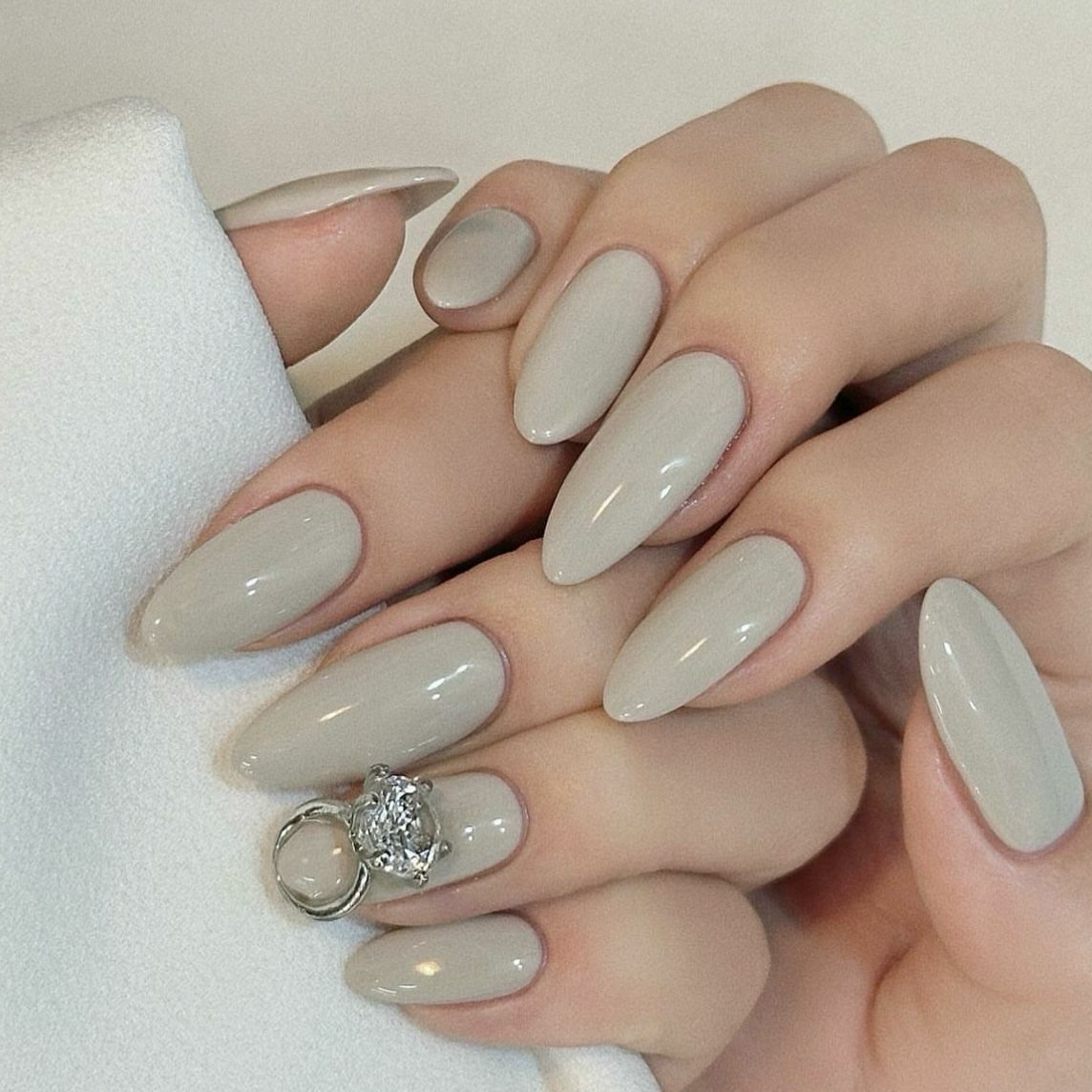 Glossy light greige almond nails