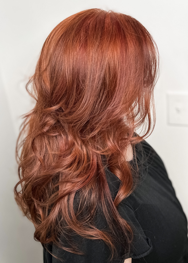 Long copper curly layered hair photographed from the back