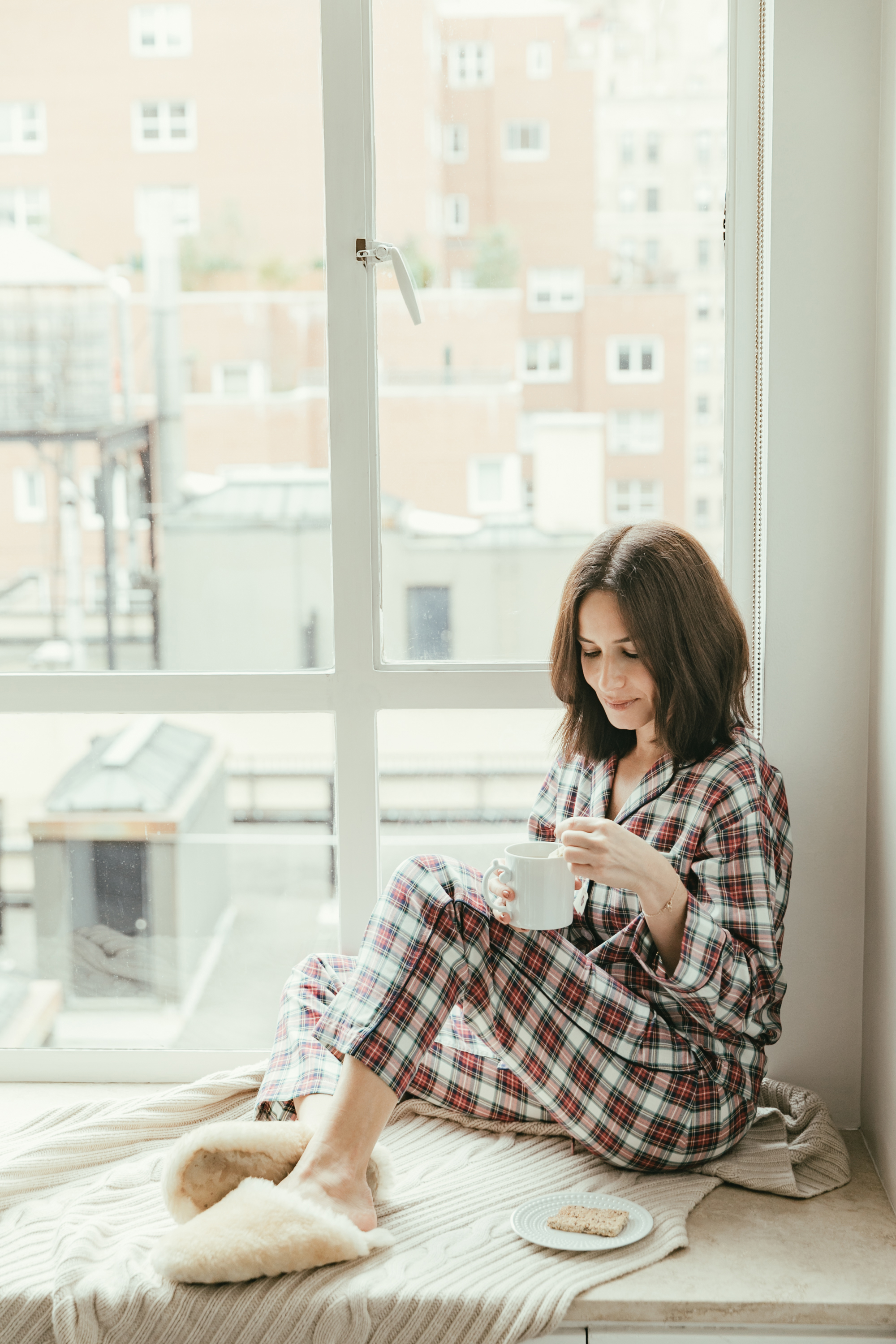 Woman wearing fluffy Ugg slides with a silk pajama set