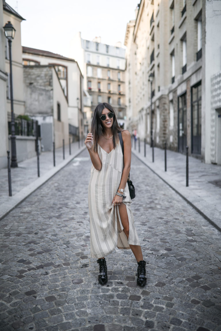 Woman on a Paris street in a cream striped maxi dress with a thigh slit and black buckled combat boots